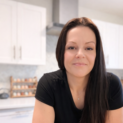 Stephanie of Serenity Falls sitting at a kitchen counter with jars and a shelf in the background